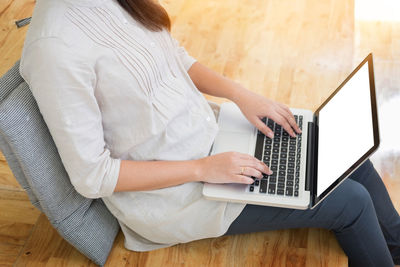 Rear view of woman using mobile phone at home