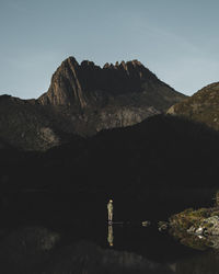 Man standing on dove lake against cradle mountain