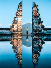 Shirtless man standing in temple amidst entrance and water