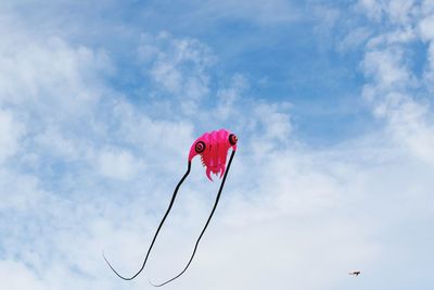 Low angle view of pink kite flying against sky