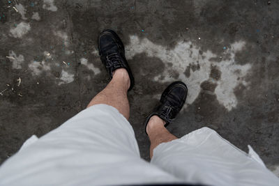 Low section of man standing on sand