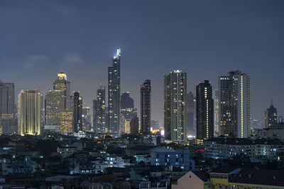 Illuminated cityscape against sky at night