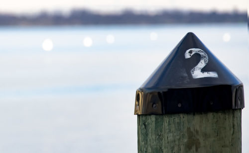 Close-up of mailbox by sea against sky