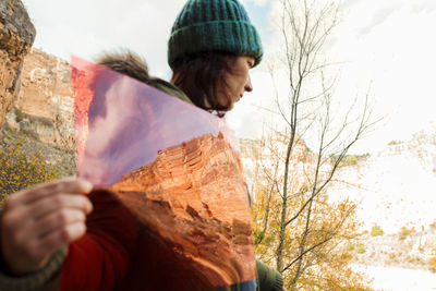 Woman in knit hat holding colored plastic