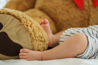 Low section of baby sleeping on bed