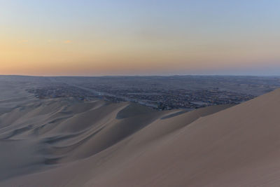 Scenic view of desert against sky during sunset