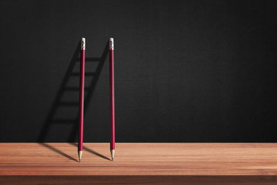 Close-up of wooden table against wall