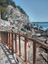 Scenic view of rocks by sea against sky