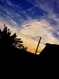 Low angle view of silhouette trees against sky