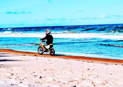 Man riding bicycle on beach