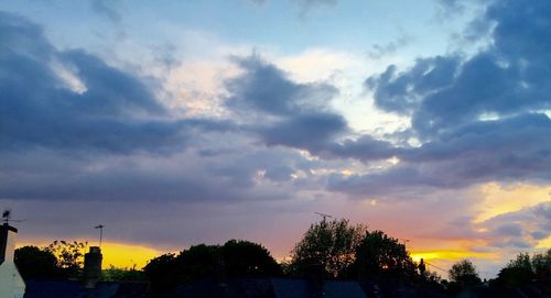 Silhouette of trees against dramatic sky