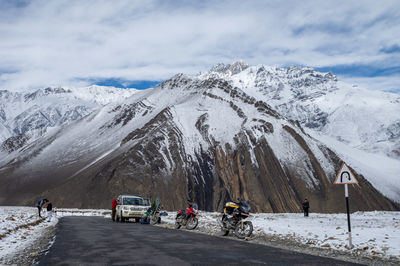 People on snowcapped mountain against sky