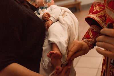 The sacrament of the baptism of a child in an orthodox church, the priest anoints the baby's feet 