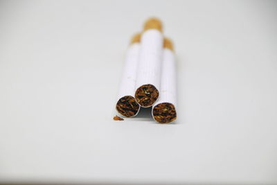 Close-up of cigarette on table against white background