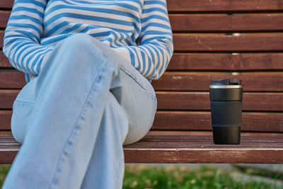 Low section of woman sitting on bench