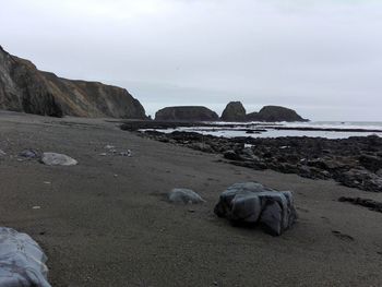 Rocks on beach against sky