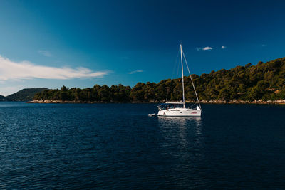 Sailboat sailing on sea against sky