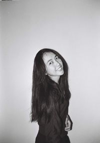 Portrait of smiling young woman against white background