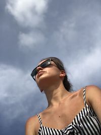 Low angle view of woman looking away against sky