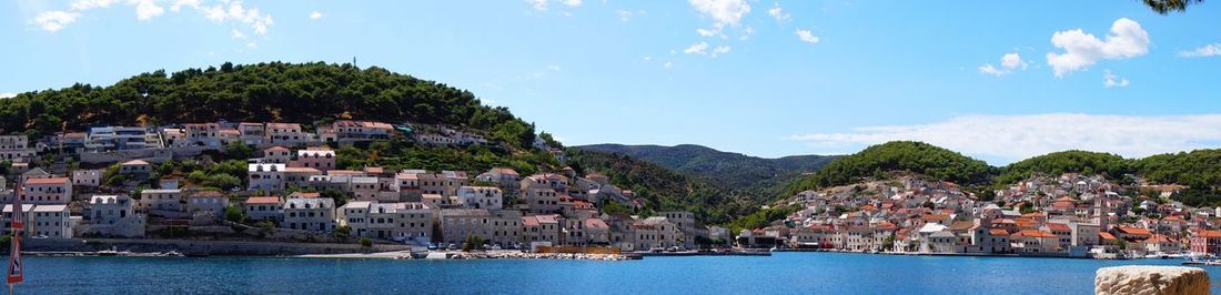 Panoramic view of town by sea against sky