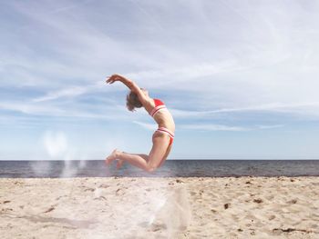 Full length of young woman at beach against sky