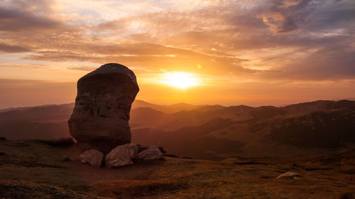 Rock formation against sky during sunset