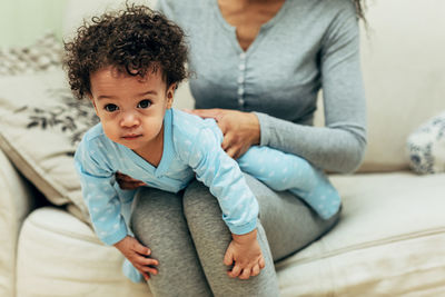 Mother and baby sitting at home