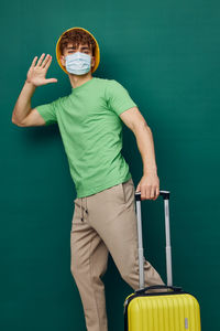 Portrait of young man standing against blue background