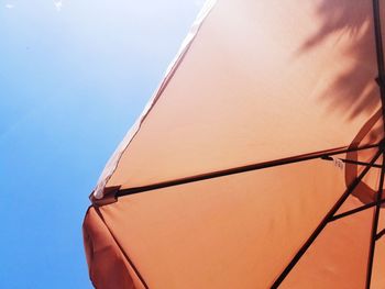 Low angle view of umbrella against a blue sky