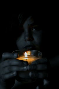 Close-up of lit candle in dark room