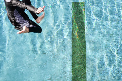 Low section of man jumping into pool