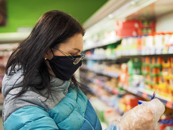 Midsection of woman with hat in store