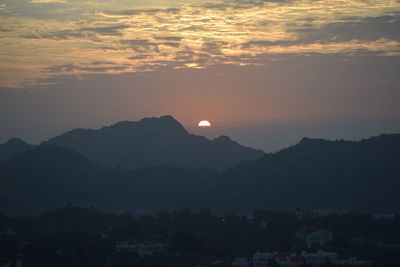 Scenic view of silhouette mountains against sky at sunset