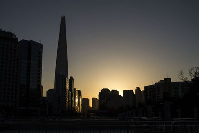 Low angle view of skyscrapers against sky during sunset