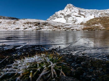 Frozen lake against snowcapped mountain