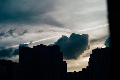 Low angle view of buildings against cloudy sky