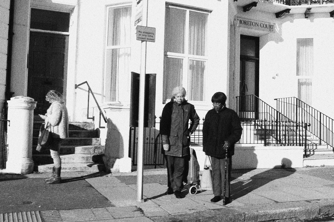 REAR VIEW OF PEOPLE WALKING ON STREET