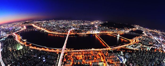 Illuminated cityscape against sky at night