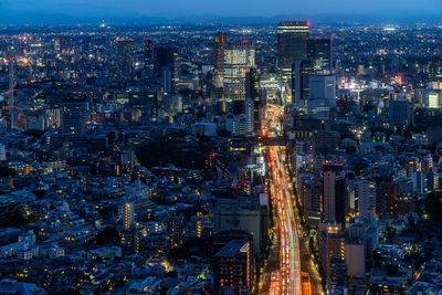 Aerial view of illuminated buildings in city at night