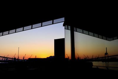 Silhouette of suspension bridge against sky during sunset