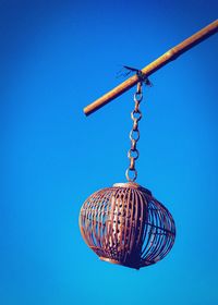 Low angle view of chain hanging against clear blue sky