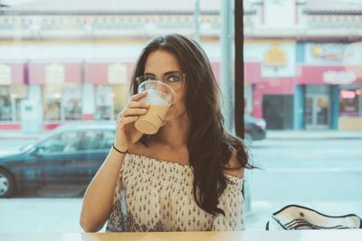 Portrait of young woman drinking glasses