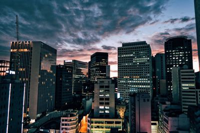 Illuminated cityscape against sky at night