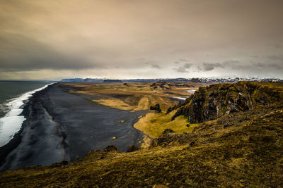 Scenic view of landscape by sea against sky