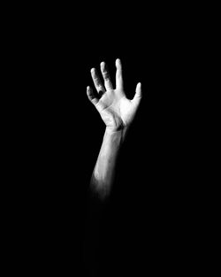 Close-up of human hand against black background