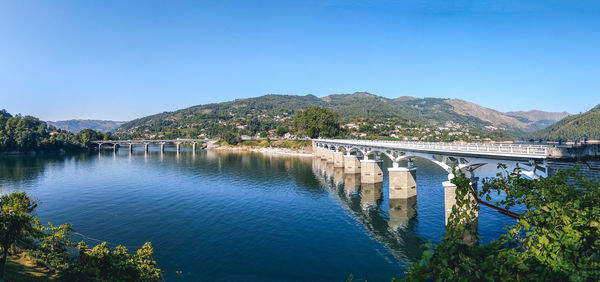 Arch bridge over river against blue sky