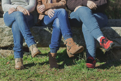 Low section of people sitting on land