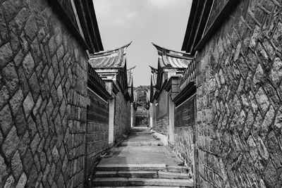 Low angle view of steps amidst buildings against sky