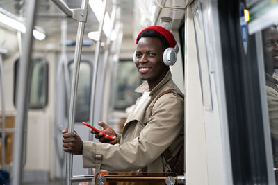 Smiling man wearing looking away sitting in train