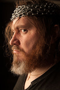 Portrait of man looking away against black background